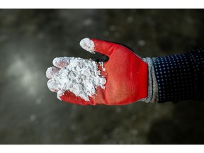 A worker holds lithium hydroxide at the Sociedad Quimica y Minera de Chile (SQM) chemical plant in Antofagasta, Chile, on Thursday, March 14, 2024. After a spectacular bust, battery-metal lithium is showing tentative signs of life on speculation the retracement that convulsed the market last year has forced the conditions for a recovery. Photographer: Cristobal Olivares/Bloomberg