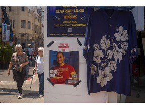 Shoppers pass posters of an Israeli hostage held in Gaza in the market in south Tel Aviv, Israel, on Tuesday, April 16, 2024.