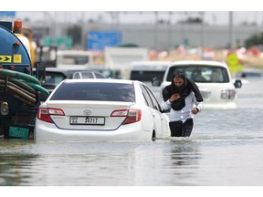 A driver walks through high water after abandoning his vehicle following a rainstorm in Dubai, United Arab Emirates, on Wednesday, April 17, 2024. The United Arab Emirates experienced its heaviest downpour since records began in 1949, Dubai's media office said in a statement.