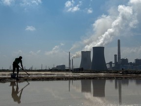 A worker on salt pans at the NLC Tamil Nadu Power Ltd thermal power plant.  (NTPL) in Tuticorin, India, on Wednesday, March 20, 2024. The world's most populous country has signaled that it will reduce its dependence on fossil fuels.  But increasing energy demand complicates the equation.