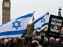Protesters wave Israeli flags and hold placards in front of Big Ben at the Houses of Parliament in central London on Nov. 26, 2023 during a demonstration to protest against antisemitism. 