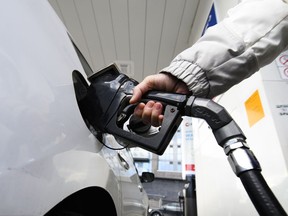 A person fills their car's gas tank