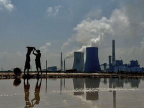 Workers make salt on salt pans adjacent to the NLC Tamil Nadu Power Limited (NTPL) thermal plant in Tuticorin, India on Wednesday, March 20, 2024.