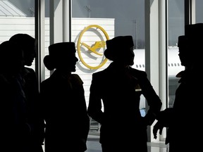FILE - In this Thursday, March 16, 2017 file photo Lufthansa flight attendants silhouetted as they pose for a photograph on occasion of the company's annual press conference in Munich, Germany. Lufthansa and a union representing cabin crew reached a pay deal Thursday, concluding the last of several major disputes that have led to strikes recently at Germany's biggest airline and in the country's wider aviation sector.