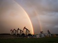 A rainbow appears to come down on pumpjacks