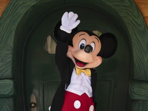 FILE - Mickey Mouse interacts with guests at Disneyland in Anaheim, Calif., Friday, April 30, 2021. Workers who help bring Disneyland's beloved characters to life said Wednesday, April 17, 2024, they have collected enough signatures to support their push for a union.