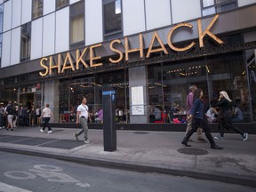 Pedestrians pass a Shake Shack restaurant in New York, U.S.