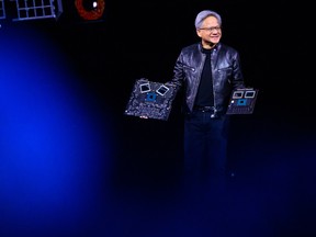 Nvidia CEO Jensen Huang with some of the company's products. A single Nvidia DGX A100 server consumes as much electricity as several U.S. households combined.