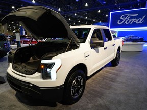 FILE - The Ford F-150 Lightning displayed at the Philadelphia Auto Show, Friday, Jan. 27, 2023, in Philadelphia. With U.S. electric vehicle sales starting to slow, Ford Motor Co. says, Thursday, April 4, 2024, it will delay rolling out new electric pickup trucks and a new large electric SUV as it adds gas-electric hybrids to its model lineup.