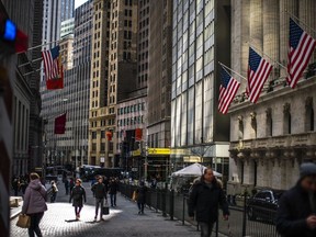 FILE - People walk past the New York Stock Exchange in New York on March 19, 2024. Global shares are mostly higher as investors looked ahead to earnings reports from top global companies and a consumer prices report that will be a gauge for U.S. inflation.