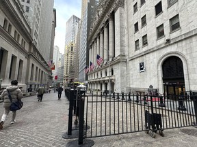 People pass the New York Stock Exchange, right, on Wednesday, April 17, 2024 in New York. Global shares are trading mixed after most U.S. stocks slipped on firmer expectations that the Fed is committed to its current rate practices.