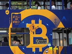 FILE - An advertisement for the cryptocurrency Bitcoin displayed on a tram, May 12, 2021, in Hong Kong. Sometime in the next few days or even hours, the "miners" who chisel bitcoins out of complex mathematics are going to take a 50% pay cut -- effectively slicing new emissions of the world's largest cryptocurrency in an event called bitcoin halving.