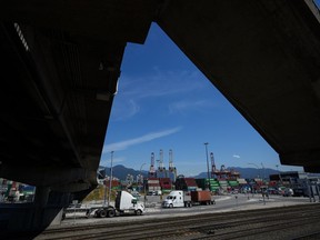 The head of Canada's biggest trucking firm says the U.S. election is softening an already weak market for freight. A transport truck carries a cargo container at port in Vancouver, on Friday, July 14, 2023.