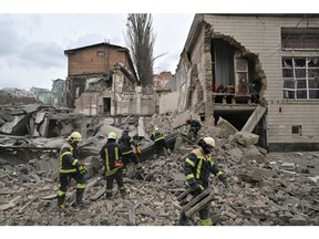TOPSHOT - Ukrainian rescuers work at the site of a missile attack in Kyiv. Photographer: Sergei Supinsky/AFP/Getty Images