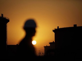 The sun sets over crude oil storage tanks at the Juaymah tank farm, operated by Saudi Aramco, in Ras Tanura, Saudi Arabia.