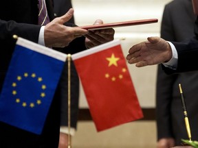FILE - A member of European Commission, left, prepares to exchange documents with Chinese delegation at a signing ceremony after the 5th China-EU High Level Economic and Trade dialogue at Diaoyutai State Guest House in Beijing, on Sept. 28, 2015. China has accused the European Union of protectionism and "reckless distortion" of the definition of subsidies in response to a new EU investigation into Chinese wind turbine makers.