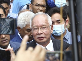 FILE - Former Malaysian Prime Minister Najib Razak, center, speaks to supporters outside at Court of Appeal in Putrajaya, Malaysia Tuesday, Aug. 23, 2022. Two managers of a Saudi oil exploration company were going on trial Tuesday, April 2, 2024, in Switzerland for alleged fraud and money laundering in a scandal years ago linked to a Malaysian sovereign wealth fund that the U.S. Justice Department once described as the "biggest kleptocracy case" ever.(AP Photo, File)