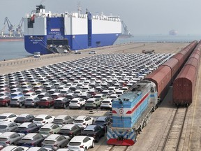 FILE - A freight train carrying cars to be exported arrives at a dock for ro-ro shipping in Yantai in eastern China's Shandong province Sunday, March 3, 2024. China's exports contracted in March after growing in the first two months of the year, underscoring the uneven nature of the country's recovery from the pandemic. (Chinatopix via AP, File)