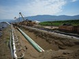 Workers lay pipe during construction of the Trans Mountain pipeline expansion on farmland, in Abbotsford, B.C., on Wednesday, May 3, 2023. The Trans Mountain oil pipeline expansion will go into commercial service on May 1.