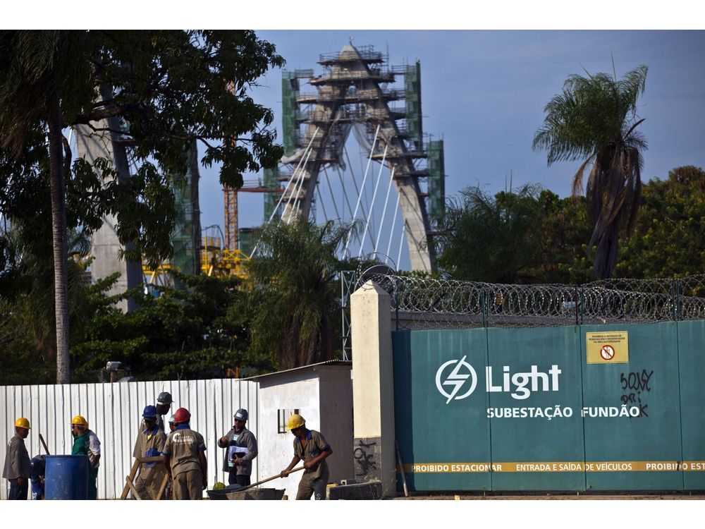 Public works employees labor at a construction site in front a Light SA electricity substation in Rio de Janeiro, Brazil, on Tuesday, Feb. 11, 2014. Brazil's electrical grid will be able to cope with hosting the soccer World Cup as temperatures and consumption diminish by the time the tournament begins, the government's deputy energy minister said last week after a blackout affected 6 million people. Photographer: Dado Galdieri/Bloomberg