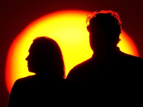 An older couple silhouetted by the sun