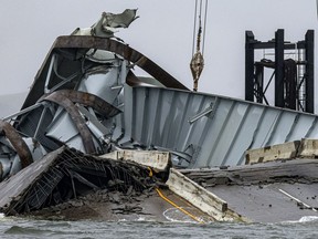 FILE - Part of the collapsed Francis Scott Key Bridge is pictured, April 3, 2024, in Baltimore. President Joe Biden is getting a firsthand look on Friday at efforts to clear away the hulking remains of the collapsed bridge, the site of a tragedy that killed six bridge workers. The visit lays bare the cleanup's high political states.