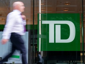 A person makes their way past a Toronto-Dominion Bank branch in Toronto, Monday, Aug. 14, 2023.