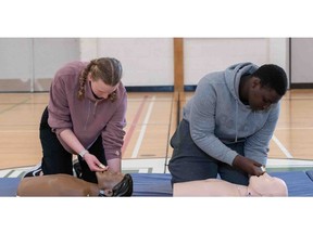 Two students demonstrate how to administer nasal Naloxone on CPR mannequins, as part of the Opioid Overdose Response Training enhancement to the ACT High School CPR and AED Program.