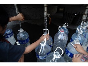 Residents collect water with plastic containers in the Tondo district in Manila, the Philippines, on Tuesday, March 22, 2022. The Philippines rate decision will be released March 24.