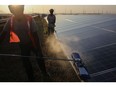 Workers wash photovoltaic panels at a solar farm in Pavagada, Karnataka, India, on Thursday, Feb. 24, 2022. India plans to expand its solar capacity to 280 gigawatts by the end of this decade from about 51 gigawatts now, but its manufacturing capacity can only currently meet around half of that requirement.
