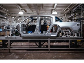 The body of a Rivian R1T electric vehicle (EV) pickup truck on the assembly line at the company's manufacturing facility in Normal, Illinois, US., on Monday, April 11, 2022. Rivian Automotive Inc. produced 2,553 vehicles in the first quarter as the maker of plug-in trucks contended with a snarled supply chain and pandemic challenges.
