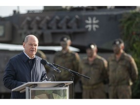 Olaf Scholz speaks with soldiers of the Bundeswehr at the Bundeswehr army training center in Ostenholz, Germany.