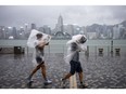 Pedestrians brace from the wind and rain on the waterfront in Tsim Sha Tsui district during a No. 8 storm signal raised for Super Typhoon Saola in Hong Kong, China, on Friday, Sept. 1, 2023. Hong Kong hunkered down on Friday as officials and residents prepared for the impact of Super Typhoon Saola, which is forecast to hit the city toward the end of the day. Photographer: Justin Chin/Bloomberg