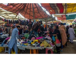 Shoppers browse clothing at a market in Karachi. Photographer: Asim Hafeez/Bloomberg