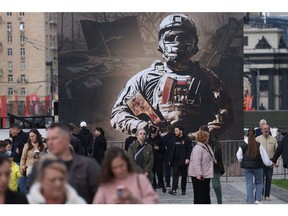 MOSCOW, RUSSIA - APRIL 28 (RUSSIA OUT) People walk past a billboard bearing the image of a Russian soldier, at the Poklonnaya Hill, April 28, 2024, in Moscow, Russia. The trophies of Russian Army exhibition, which will feature more than 30 tanks and other military vehicles from 12 countries, including the U.S., UK, France, Sweden, South Africa, Turkey, Australia and Germany, were captured in the war in Ukraine. The exhibition opens May 1.
