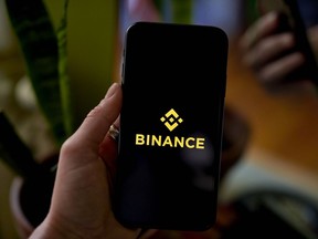 The Binance logo is seen on a smartphone
