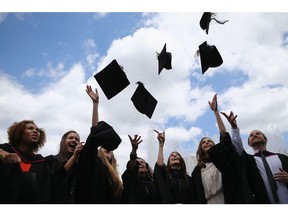LONDON, ENGLAND - JULY 15: Students throw their caps in the air ahead of their graduation ceremony at the Royal Festival Hall on July 15, 2014 in London, England. Students of the London College of Fashion, Management and Science and Media and Communication attended their graduation ceremony at the Royal Festival Hall today.
