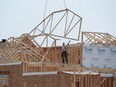 Construction workers build new homes in a development in Ottawa.