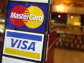 FILE - MasterCard and Visa credit card logos are shown at the entrance of a New York coffee shop, April 22, 2005. A deadline is looming for millions of businesses who may be entitled to a payout in a $5.5 billion antitrust settlement with Visa and Mastercard. The settlement stems from a 2005 lawsuit that alleged merchants paid excessive fees to accept Visa and Mastercard credit cards, and that Visa and Mastercard and their member banks acted in violation of antitrust laws.