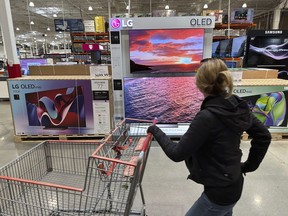 FILE - A shopper passes a display of televisions at a Costco warehouse on April 29, 2024, in Lone Tree, Colo. On Friday May 10, 2024, the University of Michigan releases its preliminary reading of consumer sentiment for May.