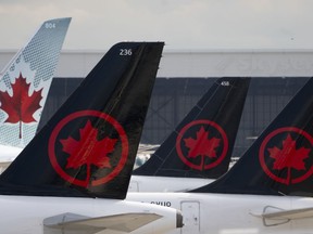 Air Canada logos are seen on the tails of planes at the airport in Montreal, Monday, June 26, 2023. Air Canada reported a loss of $81 million in its first-quarter as its operating revenue rose seven per cent.