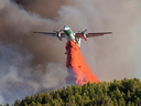 A Convair Dash 8 airtanker, used for wildfire management in Saskatchewan, drops suppression material on April 23, 2024.