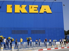 Customers maintain a safe distance from each other as they wait in line to enter an IKEA outlet in the Israeli coastal town of Netanya on April 22, 2020, after authorities eased down some of the measures that have been in place during the novel conronavirus pandemic crisis.