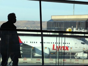 An airline passenger passes by the new Lynx Air Boeing 737 on the tarmac at the Calgary International Airport in Calgary on April 7, 2022.