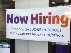 A "Now Hiring" sign is seen at a FedEx location on Broadway on June 07, 2024 in New York City.