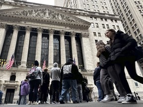 People walk past the New York Stock Exchange on March 27, 2024.