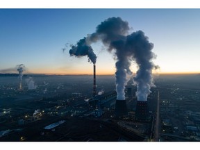 Asap dan uap air dari Pembangkit Listrik Tenaga Panas Ulaanbaatar No. 4 menggabungkan pemanas dan pembangkit listrik saat fajar di Ulaanbaatar, Mongolia, Minggu dini hari, 12 Maret 2023. Tahun ini, penghapusan pembatasan Covid Zero di Tiongkok dapat memberikan dorongan bagi perekonomian Mongolia , mengakhiri hambatan perdagangan. Fotografer: SeongJoon Cho/Bloomberg