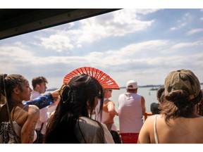 People ride the Staten Island Ferry on a warm afternoon in New York City.