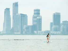 A women paddle boards along Lake Ontario during a heat wave in Toronto.