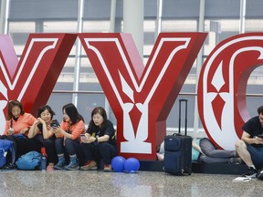 Travellers wait for flights at Calgary International Airport as WestJet mechanics strike in Calgary, Saturday, June 29.